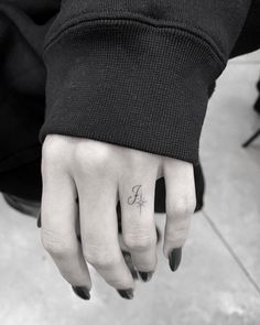 a woman's hand with a small tattoo on it