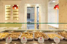 a display case filled with lots of different types of food on trays next to each other