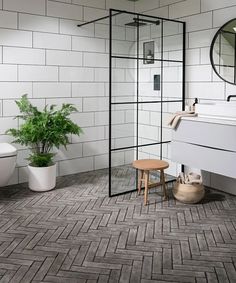 a bathroom with a shower, toilet and sink in it's corner area next to a potted plant