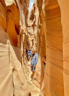 several people are walking through the narrow slots in an area that looks like a canyon