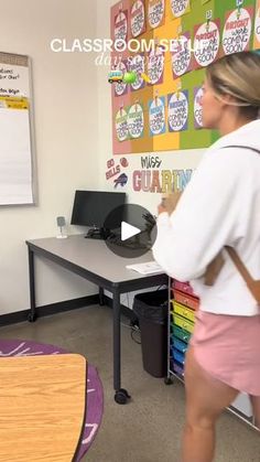 a woman in pink shorts and white shirt standing next to a desk