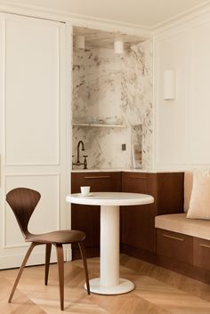 a white table and two chairs in a room with wood flooring on the walls