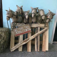 wooden crates with horse heads on them and hay in front of a blue wall that says old town kirscotti