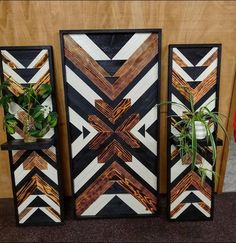 three wooden frames with plants in them on a shelf next to a wall mounted planter