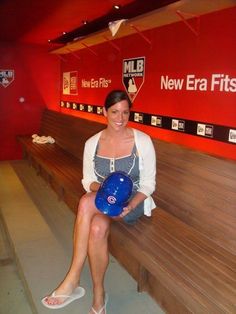 a woman sitting on a wooden bench holding a blue frisbee