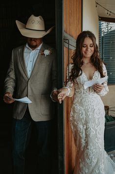 a man in a cowboy hat standing next to a woman wearing a wedding dress and holding papers