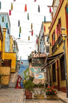 an alleyway with colorful buildings and hanging decorations