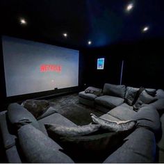 an empty theater room with two couches and a projector screen