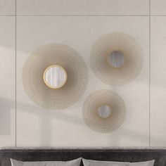 three circular mirrors mounted on the wall above a bed