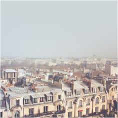 an aerial view of the roofs of buildings in paris, looking down on the eiffel tower