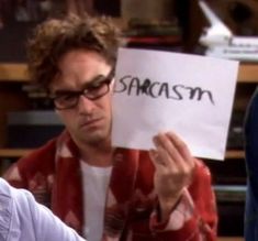 the young man is holding up a piece of paper that says samasm on it