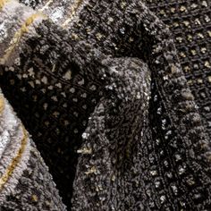 a close up view of a gray and yellow sweater with speckles on it