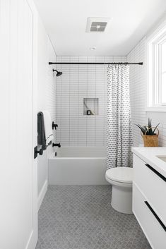 a white bathroom with black and white accessories