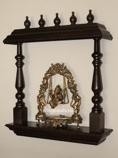 an ornate wooden shelf with a statue on it