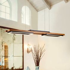 a dining room table with two vases on it and a mirror in the background