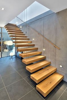 there is a wooden stair case in this modern house with concrete walls and flooring