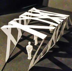 some white paper figures standing in front of a black table