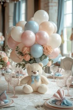 a teddy bear sitting on top of a table with balloons in the shape of flowers