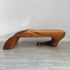 a wooden bench sitting on top of a tiled floor