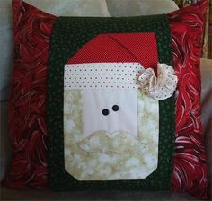 a christmas pillow with a santa clause on it's face and a bow in the corner