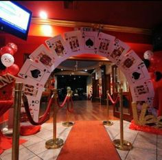 an entrance to a casino themed event with red carpet and white decorations on the walls