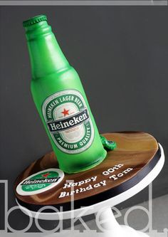 a green beer bottle sitting on top of a wooden cake plate with a happy birthday message