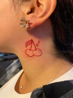 a woman with a small tattoo on her neck and behind her ear is a butterfly