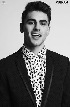 a man in a black jacket and polka dot shirt