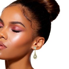 a close up of a woman with makeup on her face and wearing large gold earrings