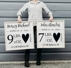 two people holding up signs that say their names and date to each other in front of a garage door