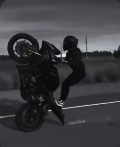 a man riding on the back of a motorcycle while holding onto it's tire