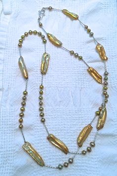 "Do you like to match your metal colors, gold with silver perhaps?  Then, this 38 inch long Golden-Hued Fresh Water Pearl with tarnish resistant Sterling Silver and Argentium Silver (.935 Silver) necklace is for you A nice option with this necklace is the Argentium Silver hand-made, by me, \"S\" clasp.  The necklace can be worn long or doubled.   This necklace can be worn for a wedding.  It also makes a great gift for a June birthday.  This necklace can dress up an outfit and it looks great with jeans and a simple top.  You decide what works for you. Pearls represent peace and love. I hand selected each Golden-Hued Fresh Water Pearl for color, shape (both length drilled stick and potato), and style.  Notice the various colors of the pearls in this necklace.  Along with the gold metal color Gold Beaded Lariat Pearl Necklace, Gold Pearl Beaded Long Necklace, Gold Long Pearl Necklace With Polished Beads, Long Gold Pearl Necklace With Polished Beads, Gold Long Necklace With Single Strand Of Round Beads, Gold Single Strand Long Necklace With Round Beads, Gold Beaded Long Pearl Necklace, Elegant Gold Necklace With Silver Beads, Gold Pearl Necklace With Silver Round Beads