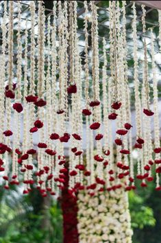 an arrangement of white and red flowers hanging from the ceiling