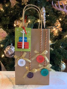 a brown paper bag with some buttons on it and a christmas tree in the background