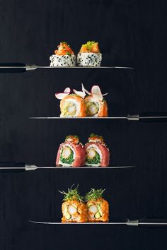 sushi is displayed on three tiers with utensils