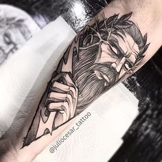 a man's leg with a black and white tattoo design on his left arm