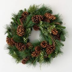 a wreath with pine cones and greenery