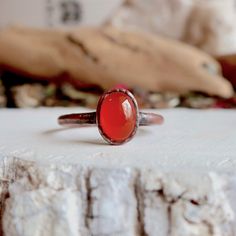 Carnelian Copper Ring Beautiful orange carnelian oval cabochon measuring 8 x 6mm and a hand hammered band. Choose either Bright Copper or Antique Copper finish. Listing is for one ring. CARNELIAN It is a stabilizing stone with high energy. It stimulates analytical capabilities and precision, allowing perceptiveness to situations and awakening your inner talents. Carnelian stimulates inquisitiveness and subsequent initiative. It is excellent for restoring vitality and motivation, and for stimulat Orange Stone Ring, Raw Stone Jewelry, Carnelian Agate, Orange Carnelian, Bright Copper, Carnelian Jewelry, Orange Stone, Carnelian Ring, Hammered Band