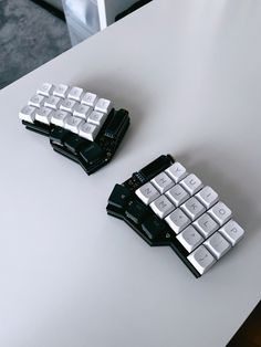 two black and white keyboards sitting on top of a table