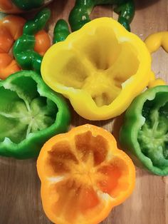 several peppers cut in half on a cutting board next to some green and orange peppers