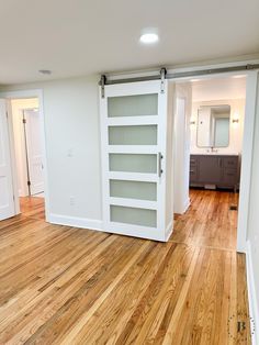 an empty room with white walls and wooden floors is seen in this image from the doorway