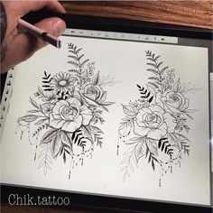 a person is drawing flowers on a sheet of paper with a marker and pen in their hand