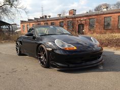 a black sports car parked in front of a brick building