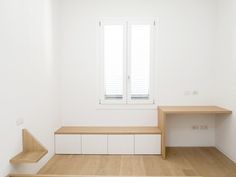 an empty room with white walls and wooden steps