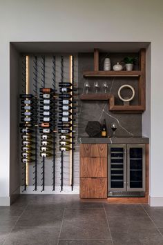 a wine rack with bottles and glasses on it in a room that has tile flooring