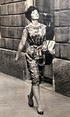 an old photo of a woman walking down the street