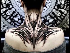 the back of a woman's neck with black feathers on her upper and lower part