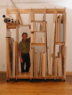 a man standing in front of a book shelf with many books on top of it