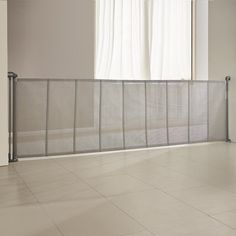 an empty room with tile flooring and a metal fence in front of the window