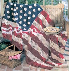 an american flag crocheted afghan on a porch with other blankets and items around it